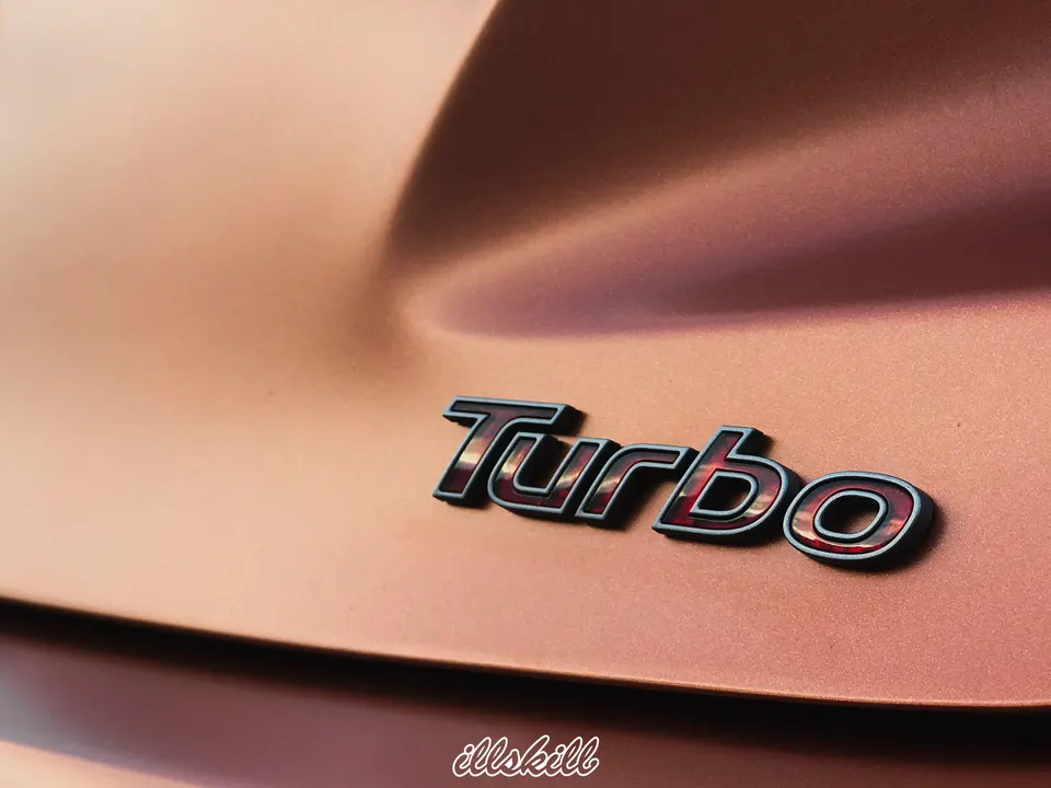 Чёрная надпись Turbo на медном кузове автомобиля