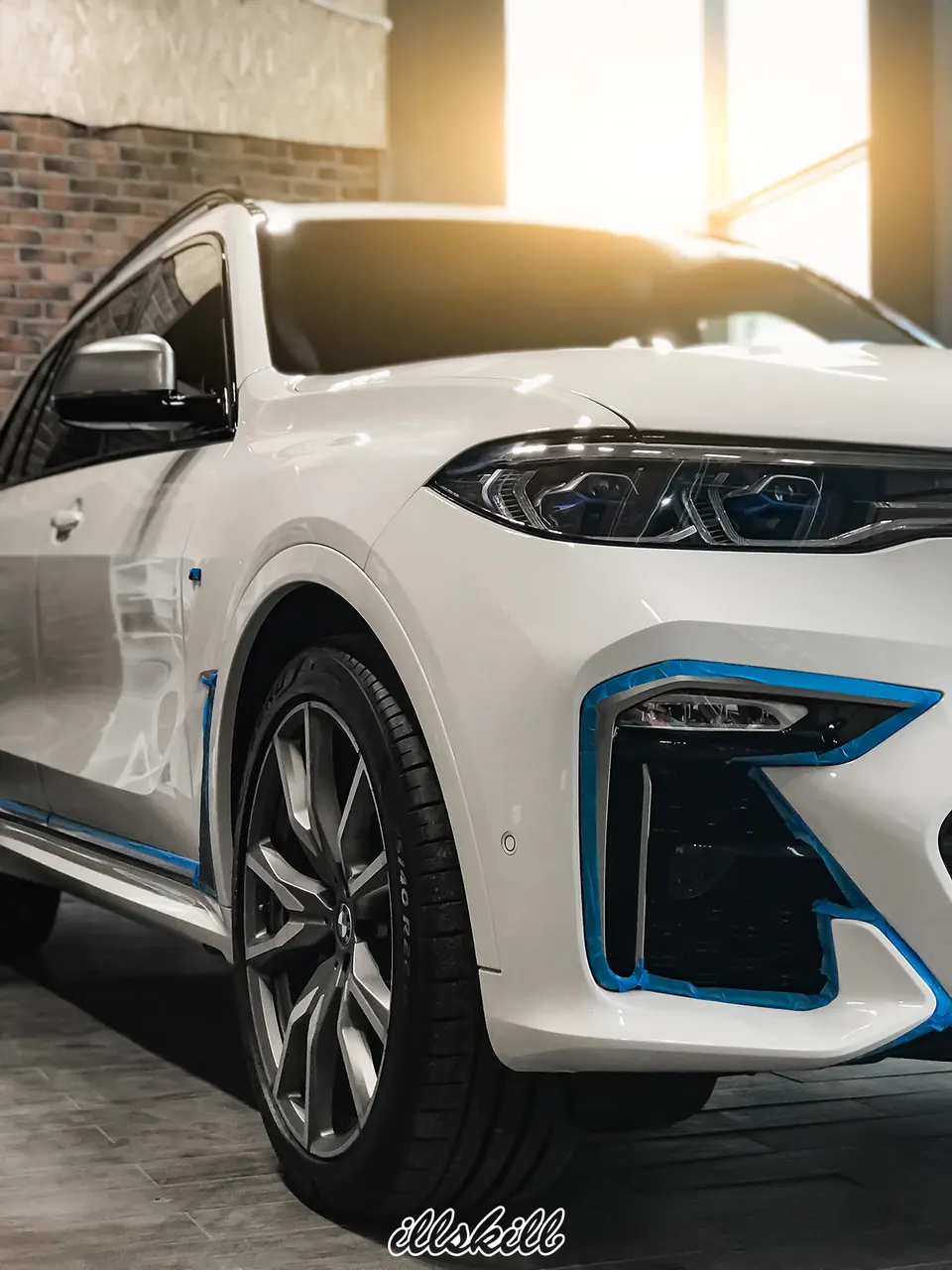 Передняя часть белого BMW с голубыми акцентами