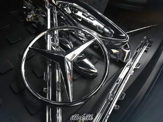 Снятые эмблемы Mercedes-Benz на тёмной поверхности