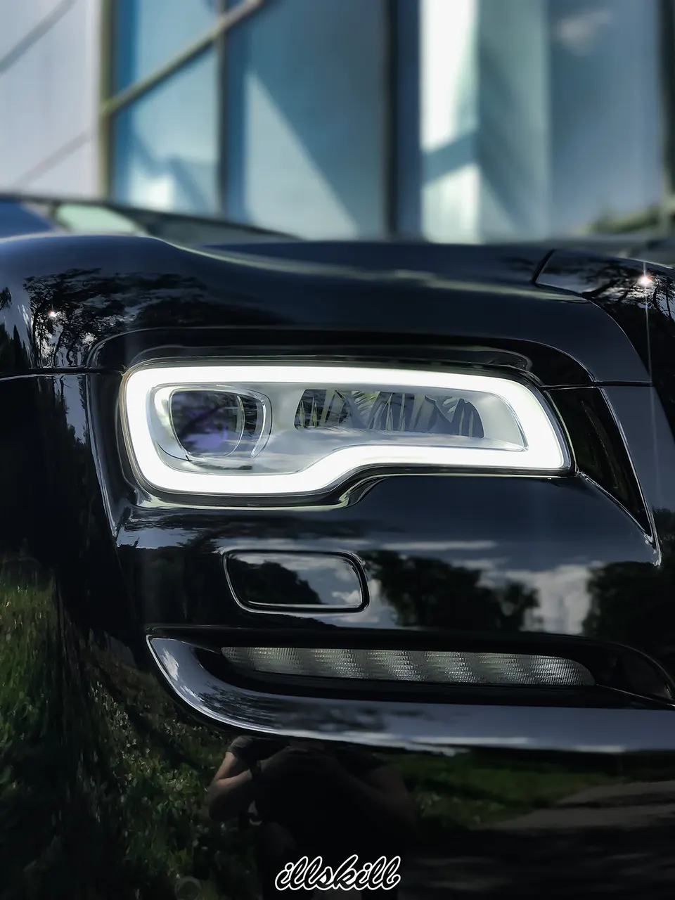 Передняя фара чёрного Rolls-Royce крупным планом