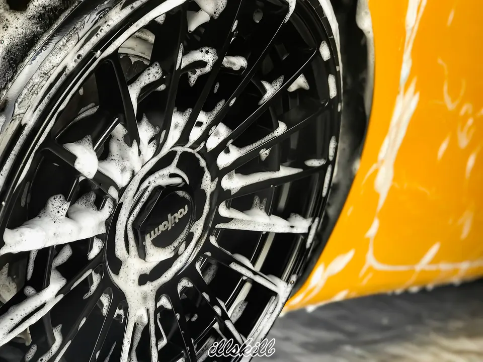 Чёрное колесо автомобиля в пене