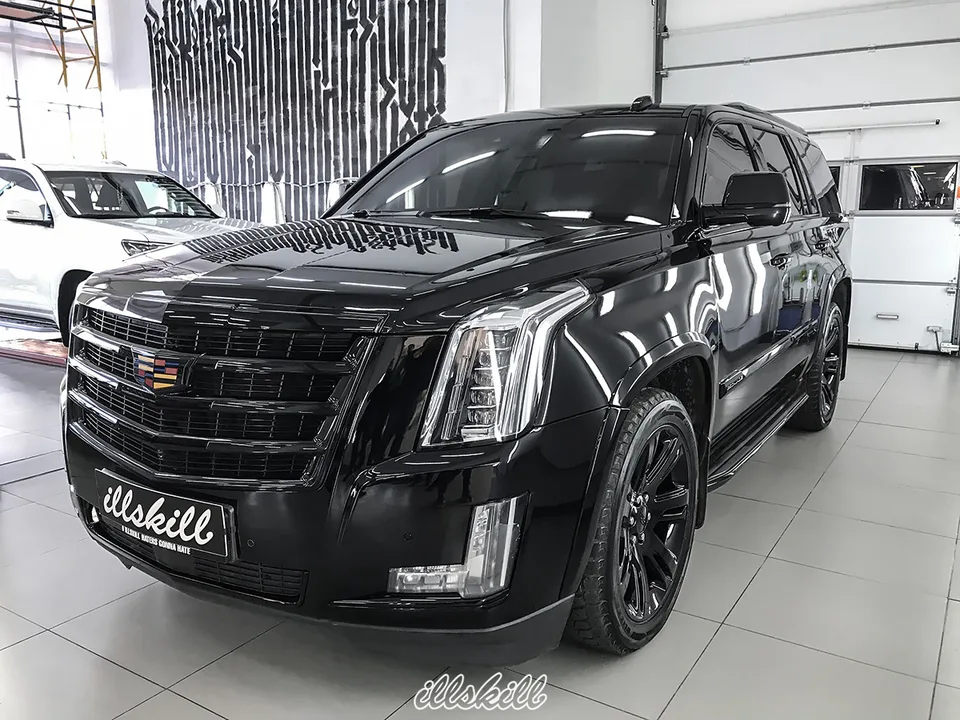 Чёрный Cadillac Escalade в мастерской, вид спереди сбоку