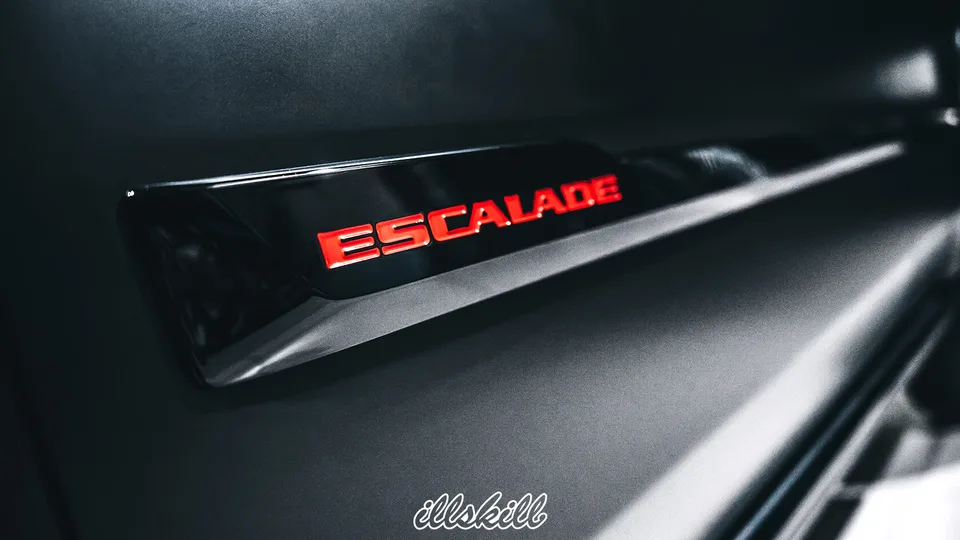 Красная надпись Escalade на чёрной боковой накладке