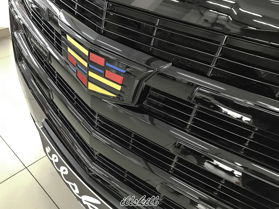 Цветная эмблема на чёрной решётке Cadillac