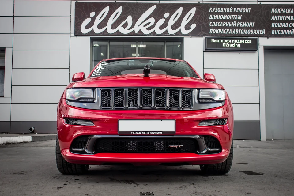 Красный Jeep Grand Cherokee SRT спереди с фигуркой на капоте.