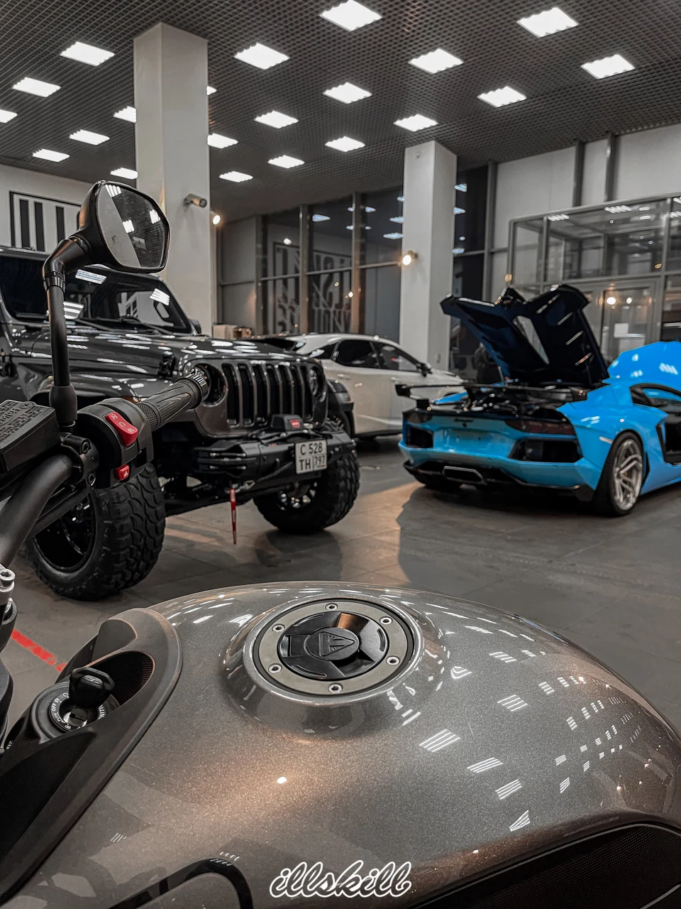 Голубой Lamborghini Aventador с открытой крышкой моторного отсека в мастерской.