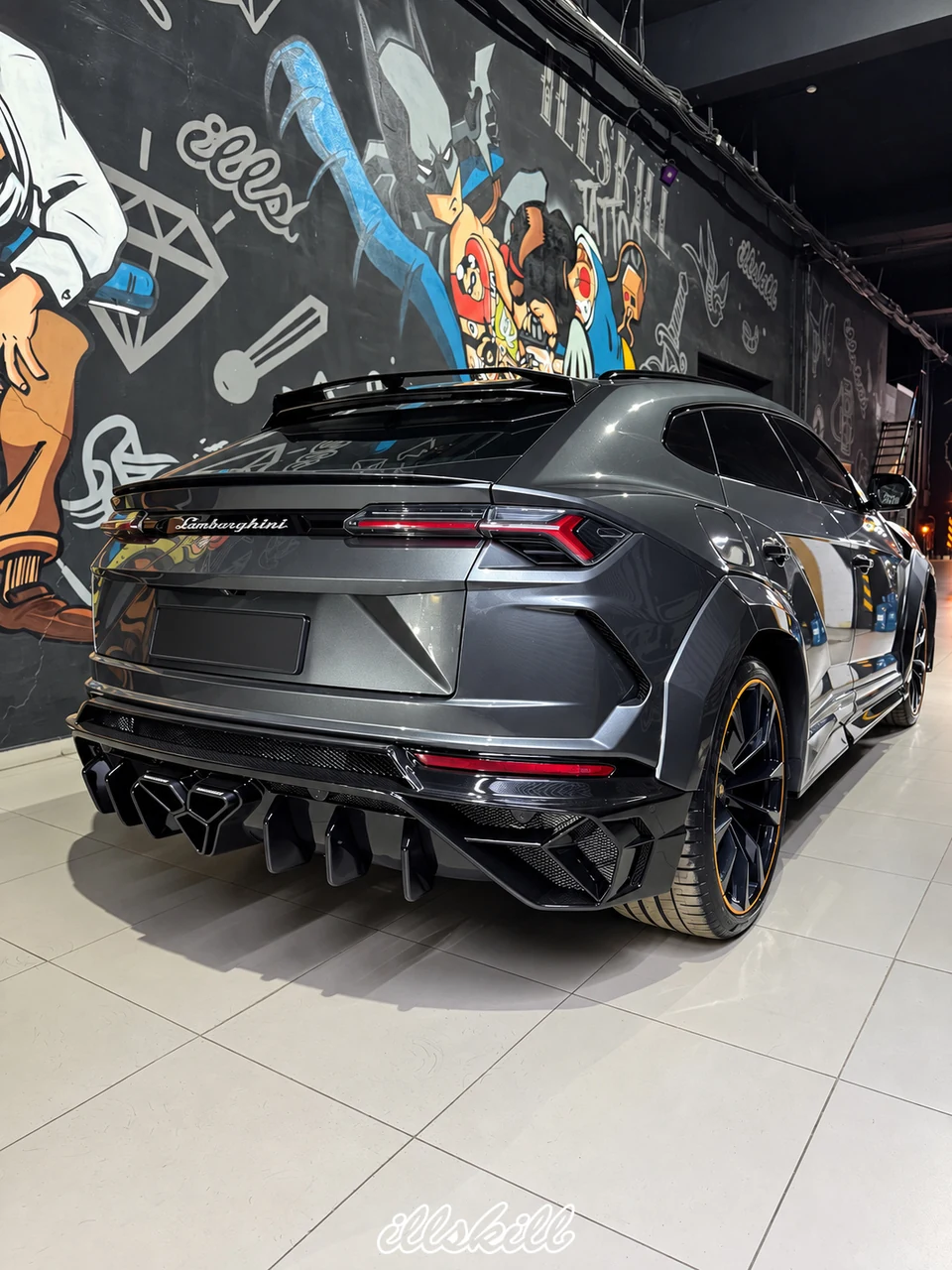 Lamborghini Urus у стены с граффити ILLSKILL: задняя часть и детали обвеса.