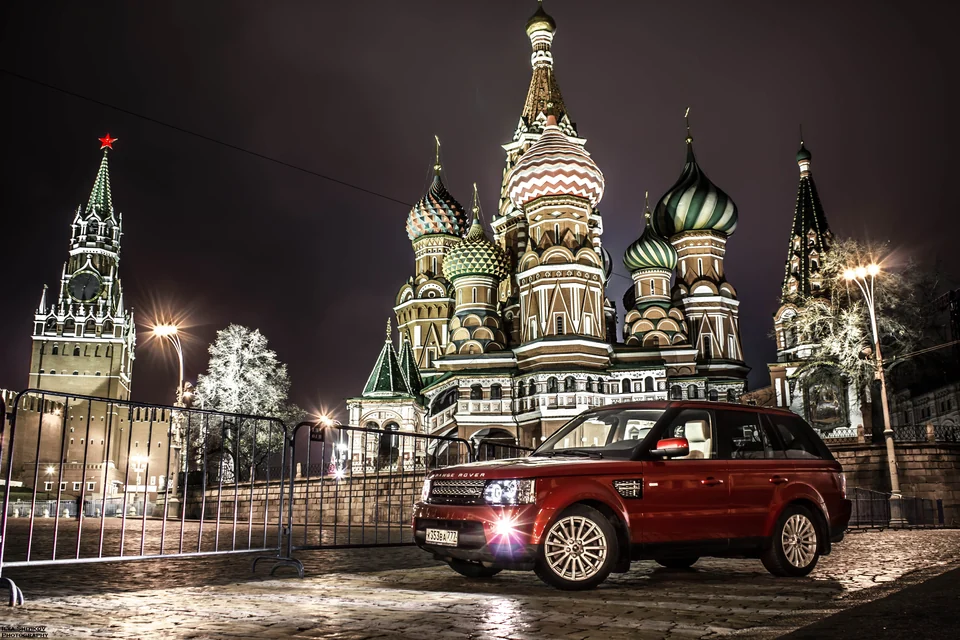 Красный Range Rover Sport вечером в центре Москвы