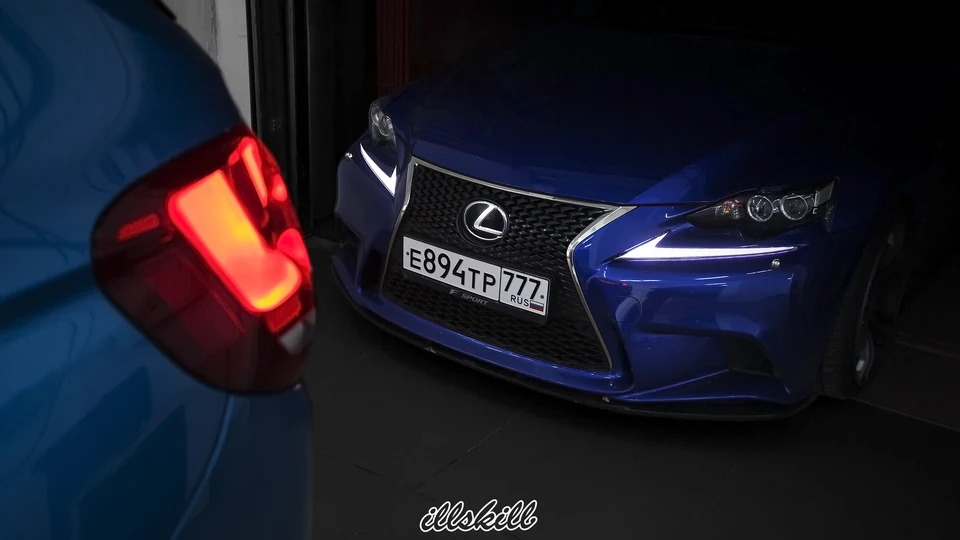 Синий Lexus IS со включёнными ходовыми огнями