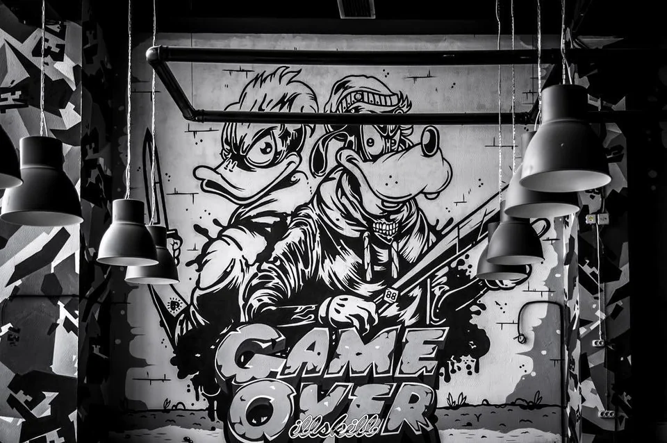 Чёрно-белая настенная графика с надписью GAME OVER и подвесными светильниками