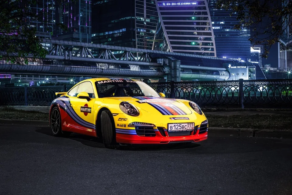 Жёлтый Porsche с цветной рекламной графикой на кузове