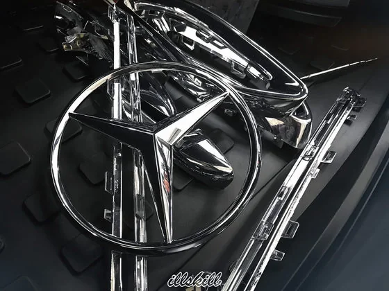 Снятые эмблемы Mercedes-Benz на тёмной поверхности