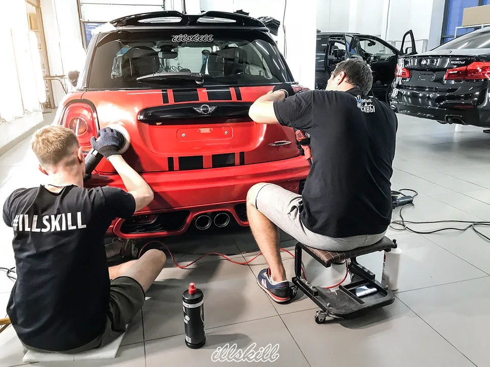 Полировка задней части красного MINI в мастерской