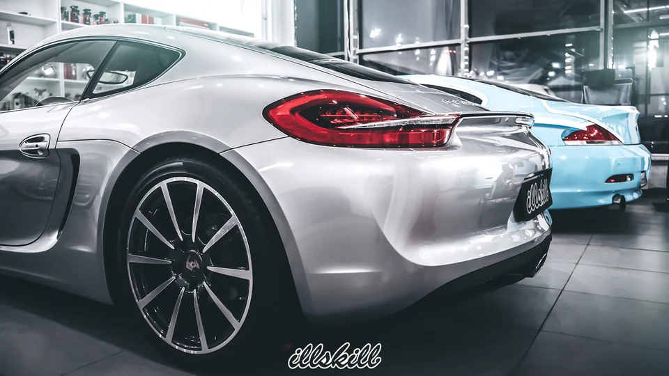 Задняя часть серебристого Porsche в мастерской