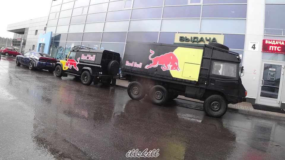 Шестиколёсный автомобиль и Land Rover Defender с красно-жёлтой графикой на чёрном кузове.