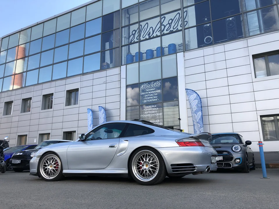 Серебристый Porsche 911 у мастерской ILLSKILL, вид сбоку.