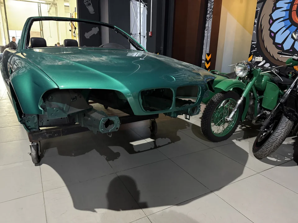 Кузов BMW Z3 на стенде: передняя часть разобрана, наружные детали сняты.