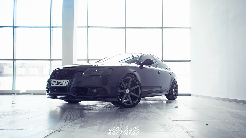 Тёмный седан Audi с графитовыми дисками в мастерской