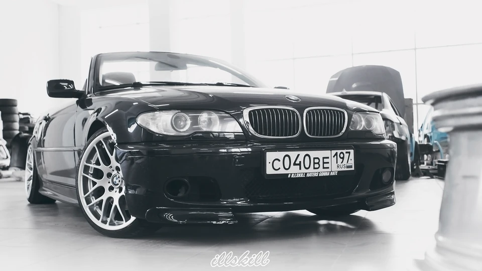 Чёрный кабриолет BMW с серебристыми многоспицевыми дисками в мастерской
