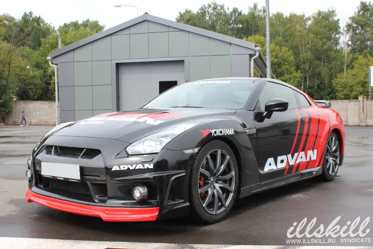 Nissan GT-R спереди сбоку: сочетание чёрных и красных участков.
