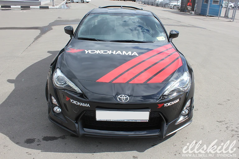 Toyota GT86 спереди: графика Yokohama на капоте и бампере.